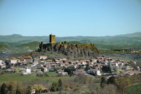 a village on a hill with a castle in the background